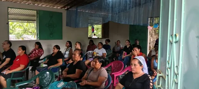 Asistentes sentados en sillas de colores dentro del templo durante el encuentro.