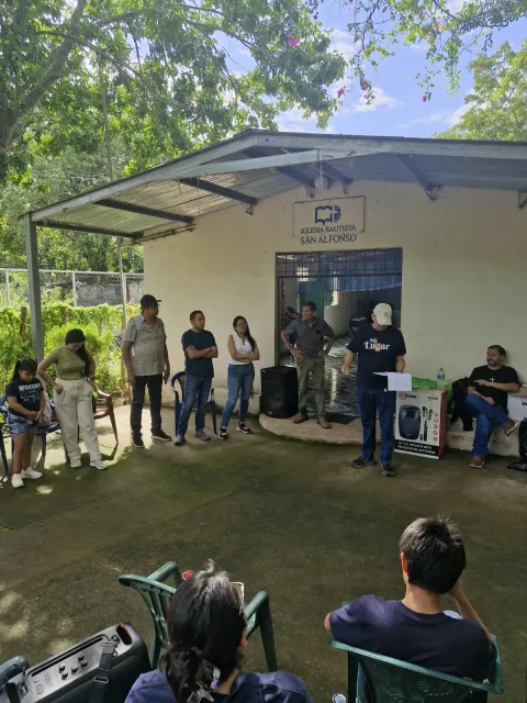 Grupo de personas reunidas frente al templo de la Iglesia Bautista San Alfonso.